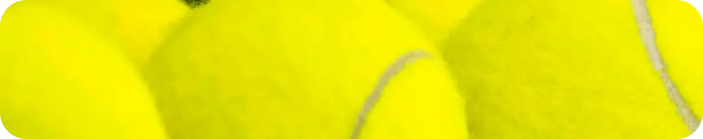 Gros plan sur des balles de tennis jaune vif alignées de manière régulière sur une étagère blanche. Les couleurs vives transmettent une impression d'énergie et de préparation